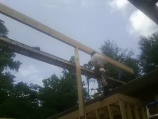 Carpenter setting a ridge beam over a new addition frame — Ice Dam Removal by Roofing Brothers in Fort Oglethorpe
