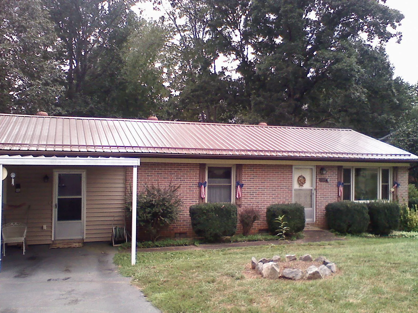 Bronze metal roof and carport on a brick ranch home — Roof Repair work by our crew in Fort Oglethorpe
